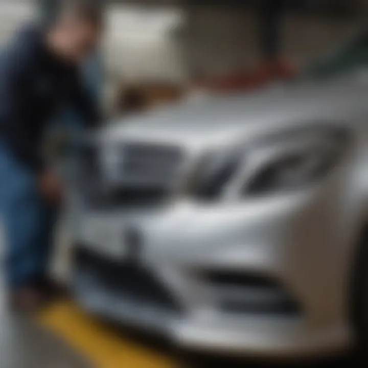 Mechanic assessing a Mercedes Benz bumper for repair.